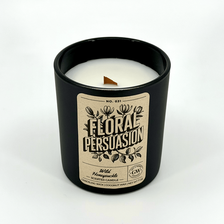Candle in a black container with a &