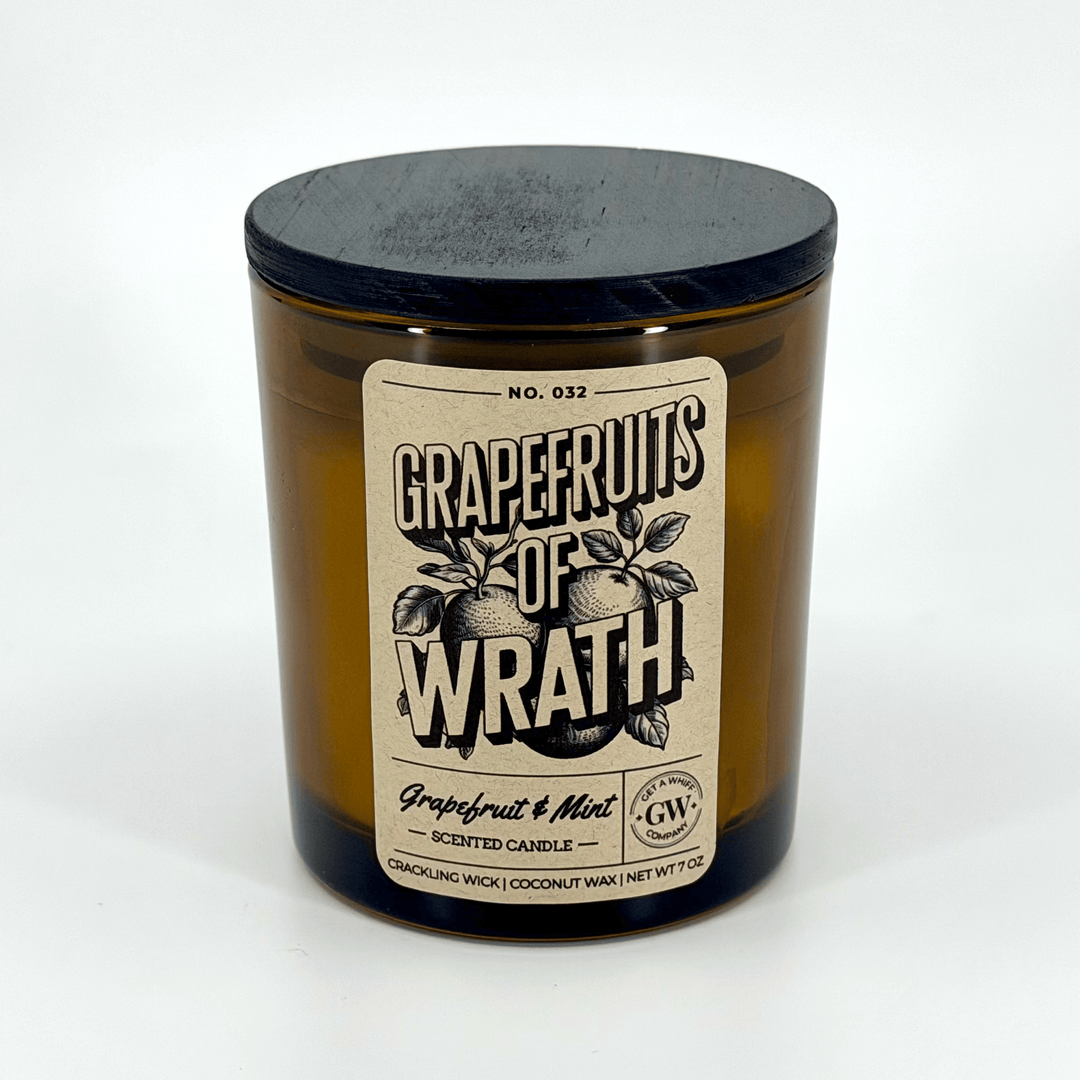 Grapefruits of Wrath scented candle with a black lid on a white background