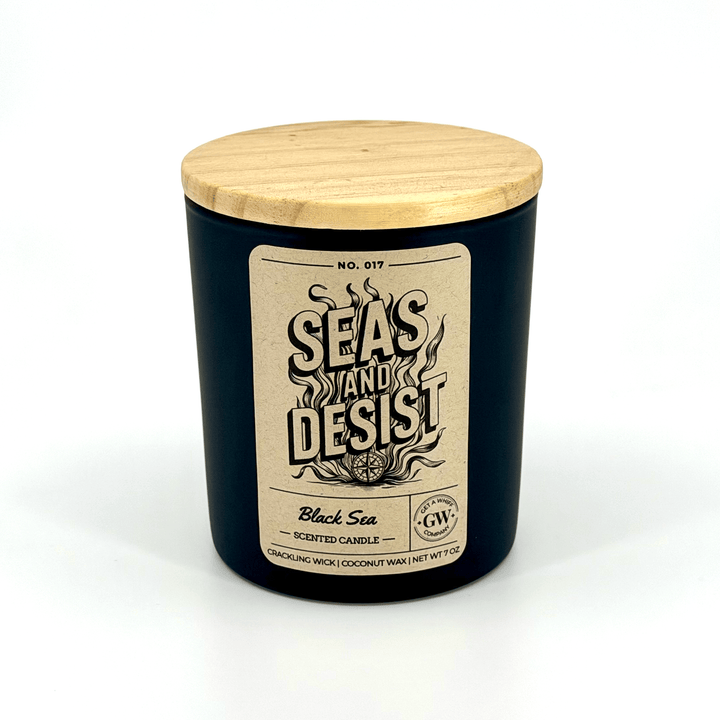 Black candle with wooden lid and label on a white background