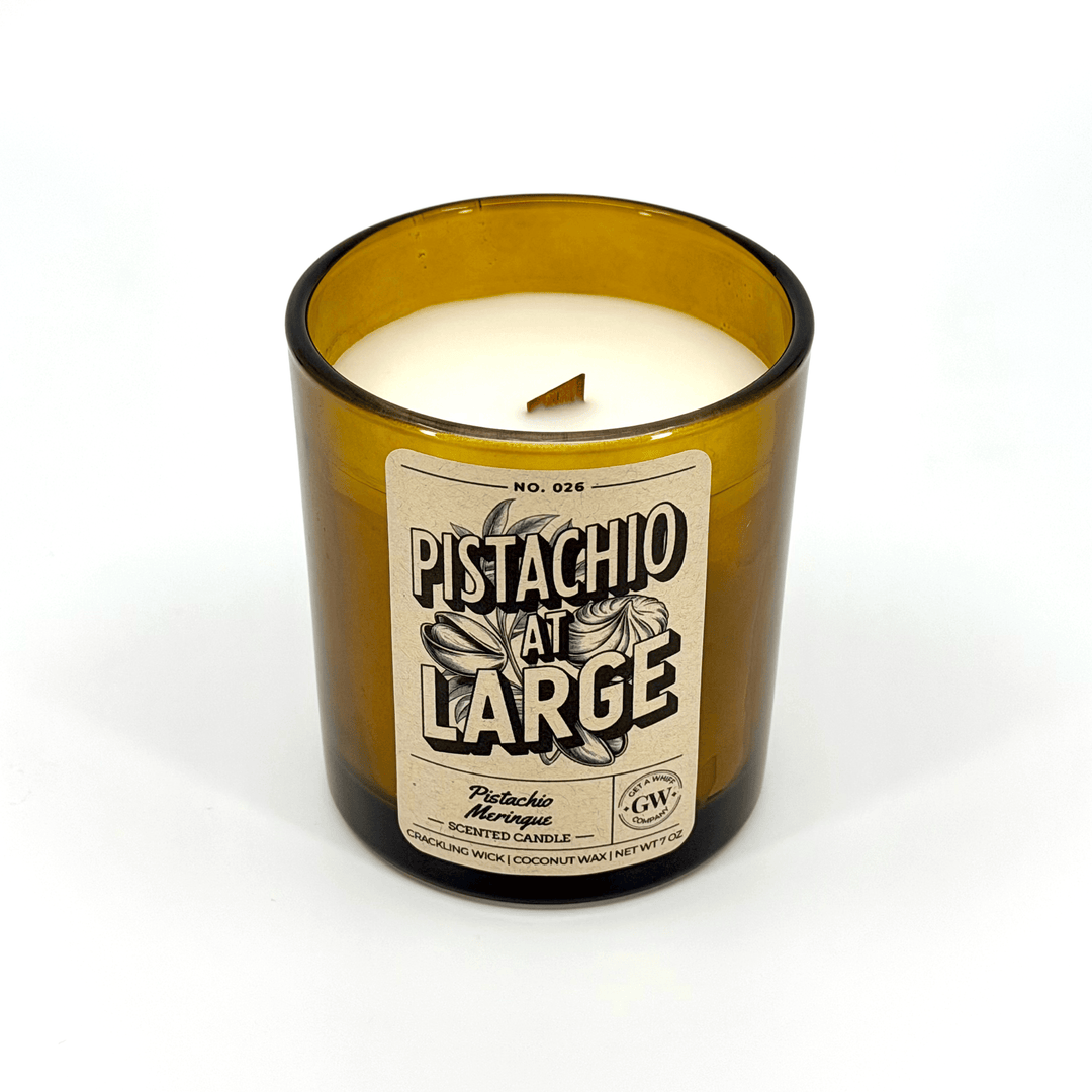 Candle in an amber glass bottle with a label on a white background