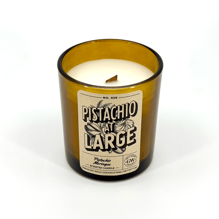 Candle in an amber glass bottle with a label on a white background