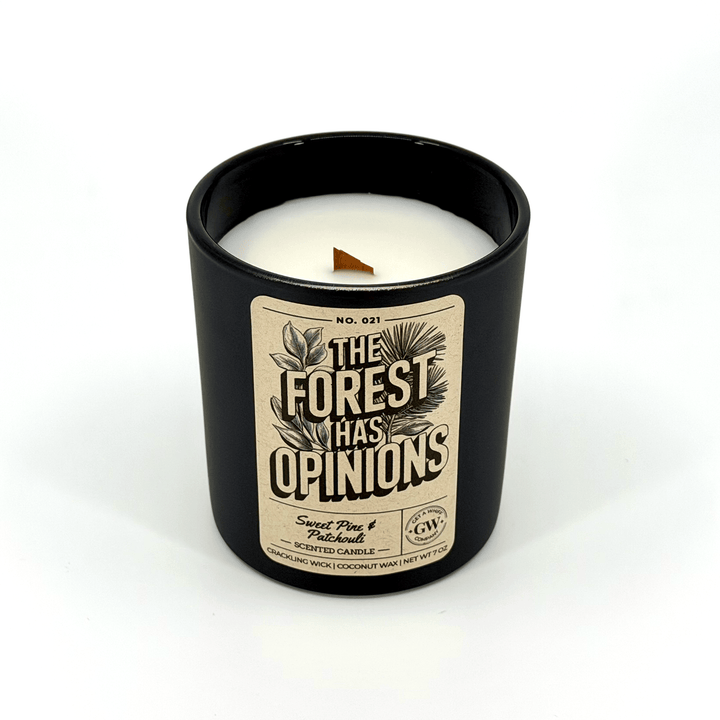 Candle in a black container with a label reading &