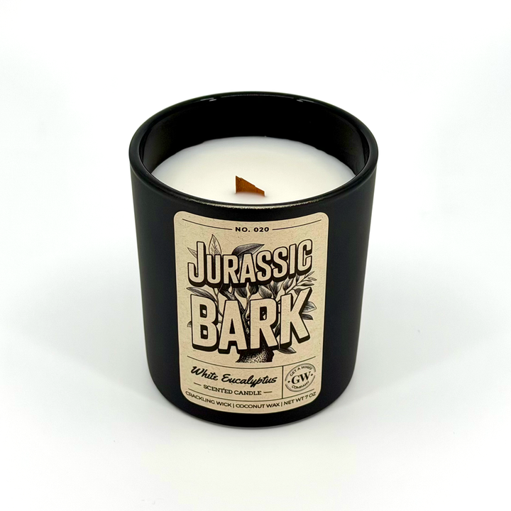 Candle in a black container with a &