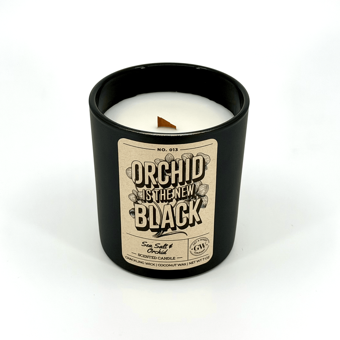 Candle in a black container with a label on a white background