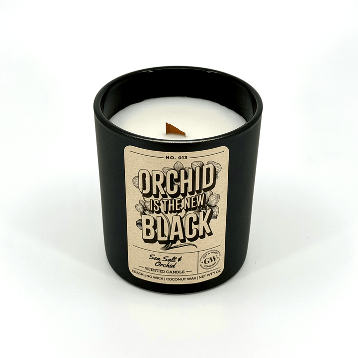 Candle in a black container with a label on a white background